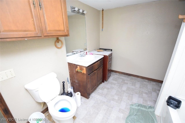 bathroom featuring baseboards, tile patterned floors, toilet, and vanity