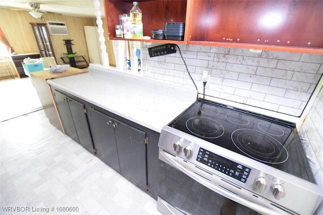 kitchen with tasteful backsplash, light floors, electric range, light countertops, and a wall mounted AC