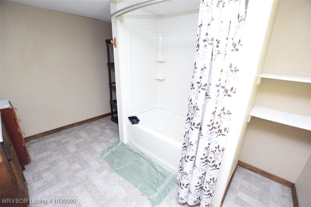 bathroom with shower / tub combo with curtain and baseboards