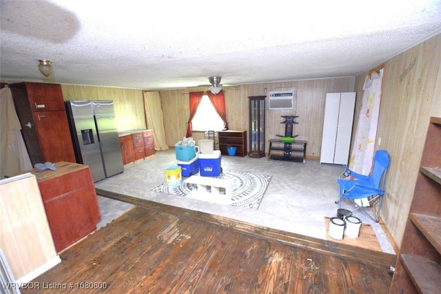 playroom with a textured ceiling, wooden walls, and a wall mounted air conditioner