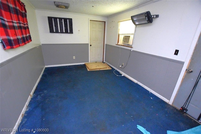 carpeted empty room featuring cooling unit, a textured ceiling, and crown molding