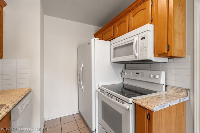 101 Saskatchewan Rd, Roland, OK 74954 - kitchen featuring white appliances, tasteful backsplash, light tile patterned flooring, and brown cabinets