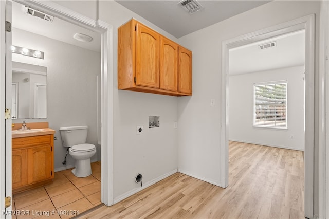 101 Saskatchewan Rd, Roland, OK 74954 - laundry room with washer hookup, electric dryer hookup, light wood-style floors, and baseboards