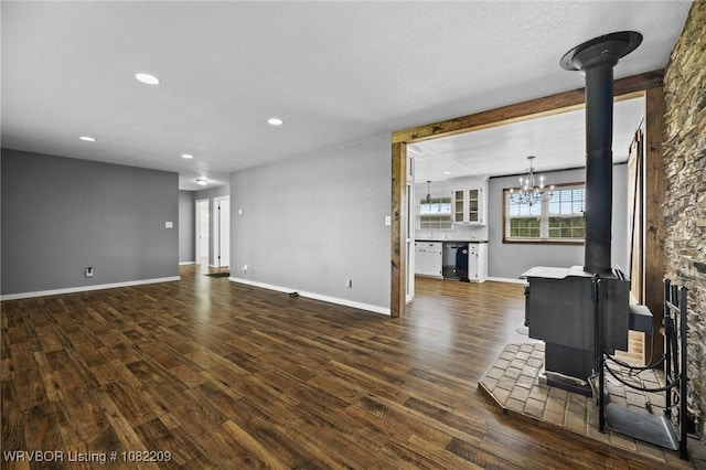 6106 Dean Rd, Alma, AR 72921 - unfurnished living room with a wood stove, a chandelier, dark wood-style floors, and recessed lighting