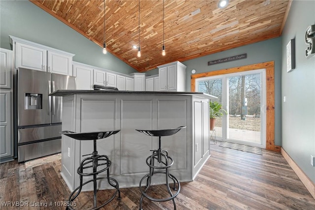 kitchen featuring white cabinets, wood ceiling, and stainless steel fridge