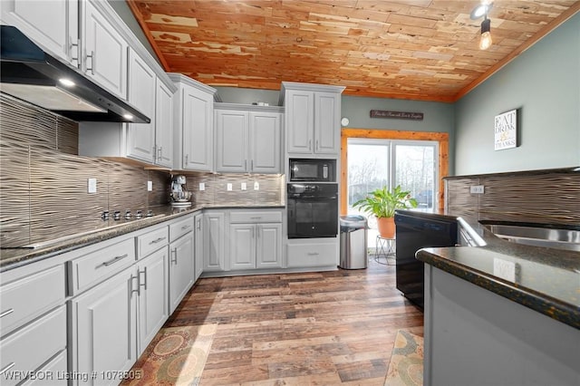 kitchen featuring black appliances, light wood-type flooring, white cabinets, and backsplash