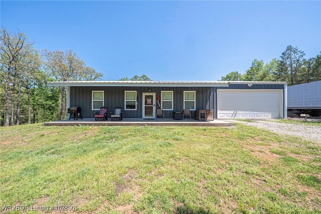 ranch-style home with metal roof, a garage, dirt driveway, and fence