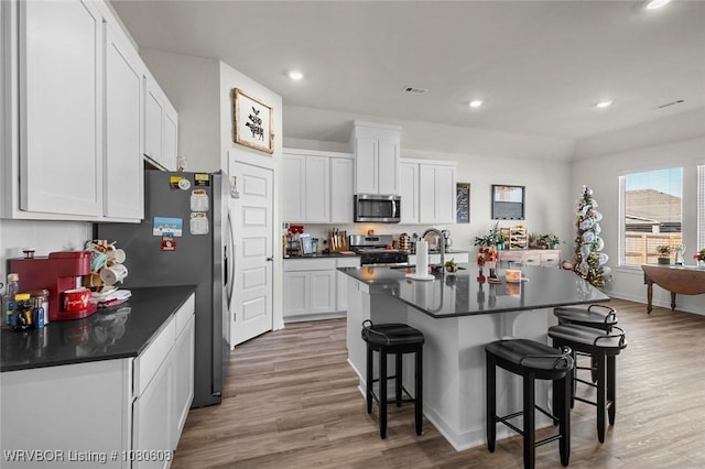 3912 Kent Ln, Springdale, AR 72764 - kitchen featuring dark countertops, appliances with stainless steel finishes, a kitchen bar, and a sink