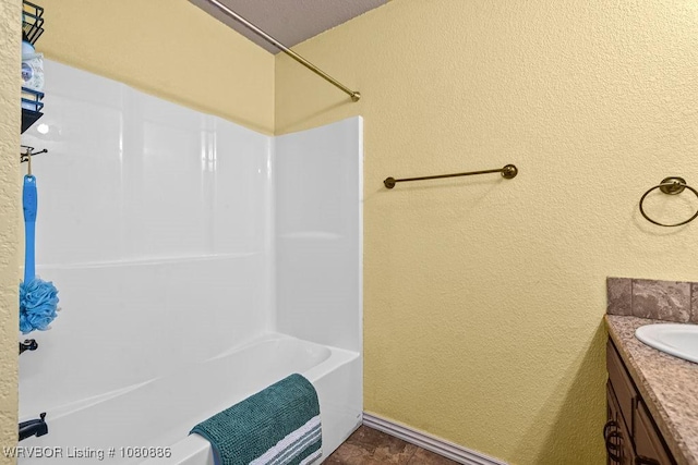 1917 Fisher Rd, Muldrow, OK 74948 - bathroom with a textured wall, vanity, shower / washtub combination, and baseboards