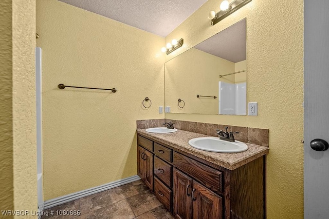 1917 Fisher Rd, Muldrow, OK 74948 - bathroom featuring a textured wall, a textured ceiling, stone finish flooring, double vanity, and a shower