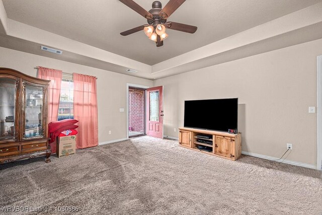 1917 Fisher Rd, Muldrow, OK 74948 - unfurnished living room featuring baseboards, carpet floors, a ceiling fan, and a raised ceiling