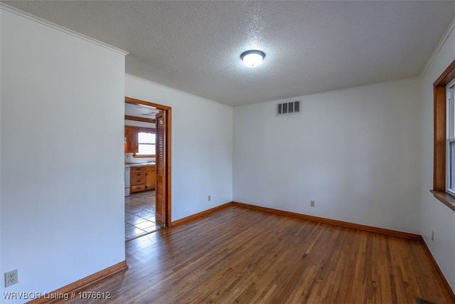 spare room with a textured ceiling and hardwood / wood-style flooring