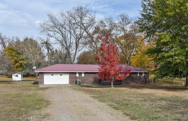 view of front of property with central air condition unit, a garage, a front yard, and a storage unit