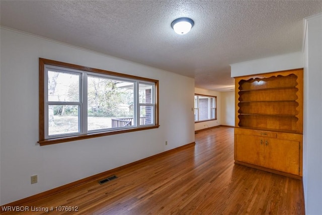 spare room featuring hardwood / wood-style flooring and a textured ceiling