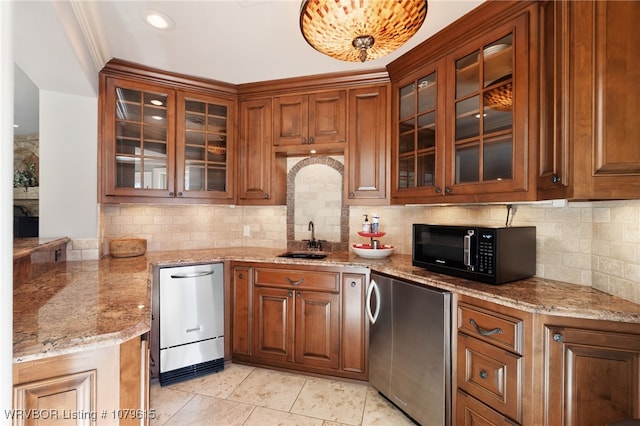 kitchen featuring refrigerator, a sink, black microwave, stainless steel dishwasher, and brown cabinets