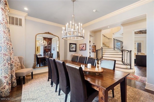 dining room with visible vents, stairs, an inviting chandelier, and wood finished floors