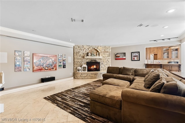 living room with visible vents, recessed lighting, a fireplace, crown molding, and baseboards