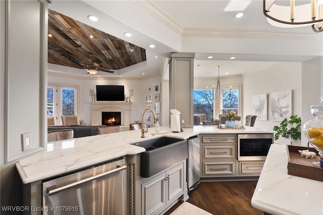 kitchen featuring stainless steel dishwasher, an inviting chandelier, built in microwave, and a sink