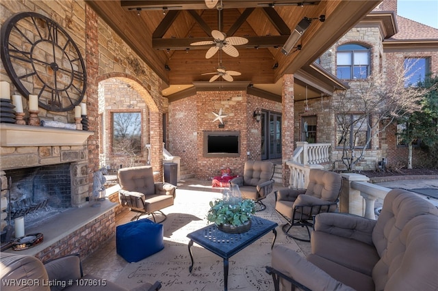 view of patio / terrace with an outdoor living space with a fireplace and ceiling fan