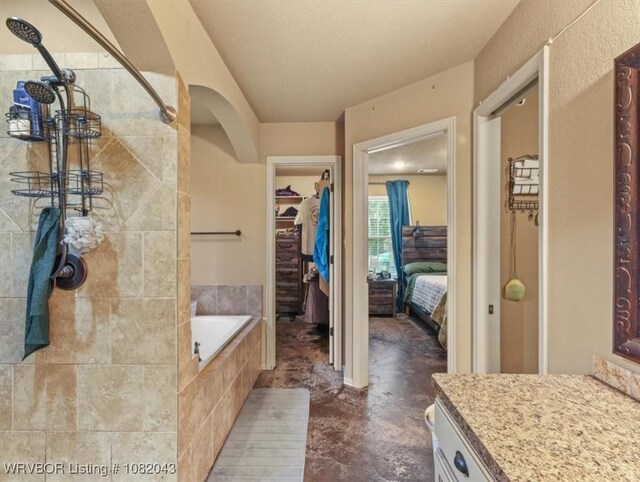 1112 Persimmon St, Greenwood, AR 72936 - full bath featuring a garden tub, connected bathroom, a walk in closet, vanity, and a tile shower