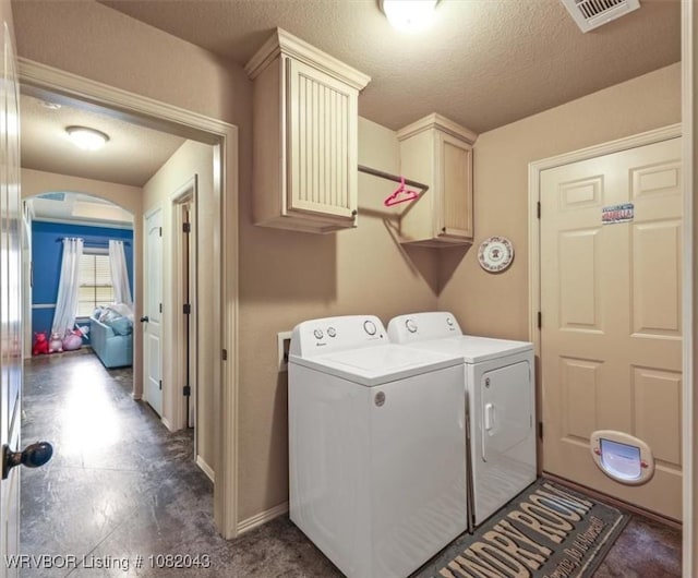 1112 Persimmon St, Greenwood, AR 72936 - laundry area featuring separate washer and dryer, cabinet space, arched walkways, and a textured ceiling