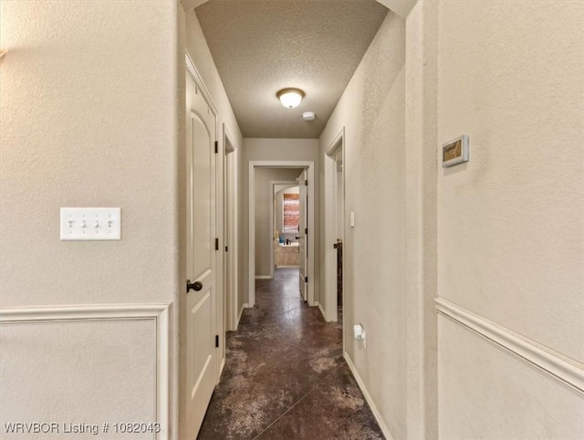 1112 Persimmon St, Greenwood, AR 72936 - hallway featuring a textured ceiling, a textured wall, and concrete flooring