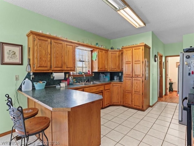 87387 S 4719, Stilwell, OK 74960 - kitchen with tasteful backsplash, kitchen peninsula, sink, and a textured ceiling