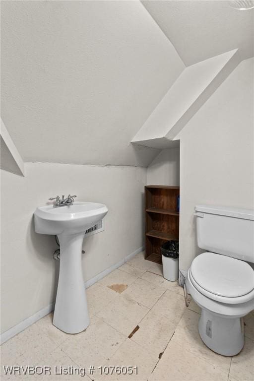 bathroom with vaulted ceiling and toilet