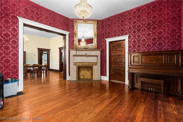 unfurnished living room with hardwood / wood-style flooring, a notable chandelier, and a high end fireplace