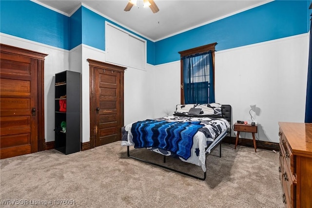 carpeted bedroom featuring ceiling fan and ornamental molding