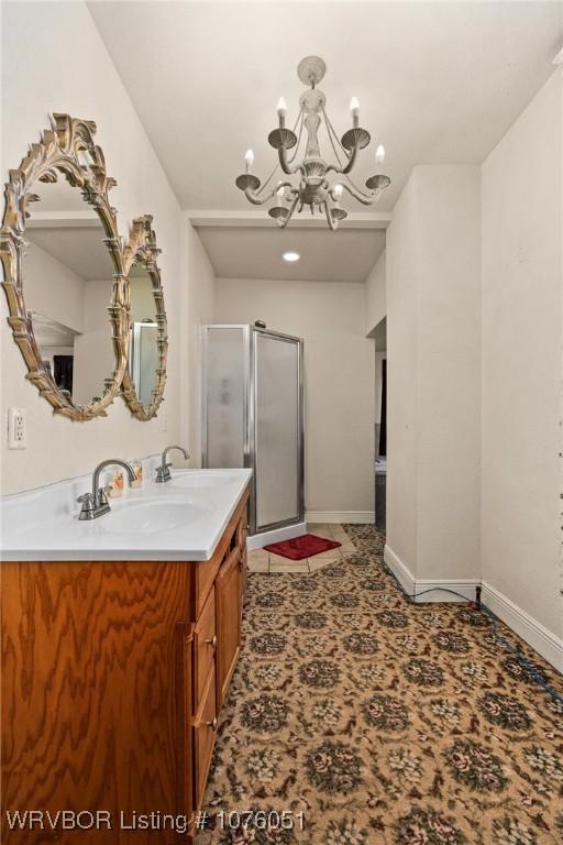 bathroom with vanity, an enclosed shower, and a notable chandelier