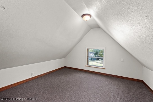 bonus room featuring carpet flooring, a textured ceiling, and lofted ceiling