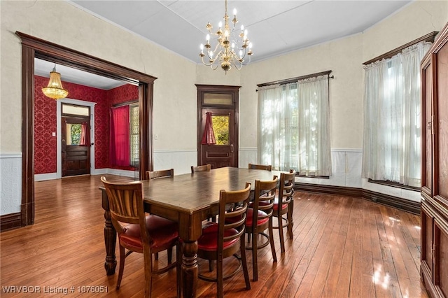 dining space with hardwood / wood-style flooring and an inviting chandelier