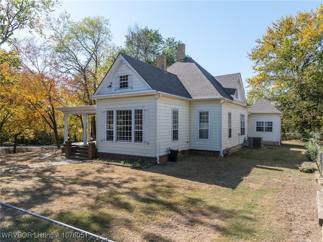 back of property featuring covered porch, a yard, and central AC