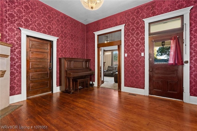 entryway with dark hardwood / wood-style flooring and a notable chandelier