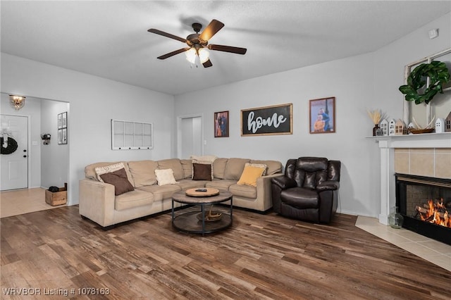 living room with a tile fireplace, ceiling fan, and hardwood / wood-style flooring