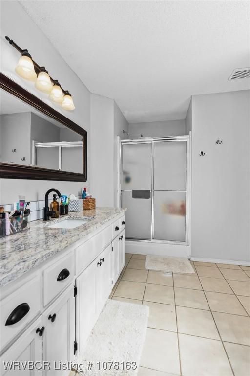 bathroom featuring vanity, tile patterned floors, and an enclosed shower