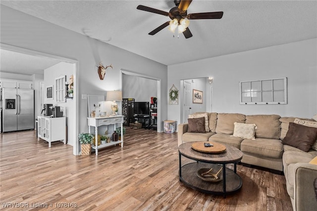 living room with hardwood / wood-style floors, a textured ceiling, and ceiling fan