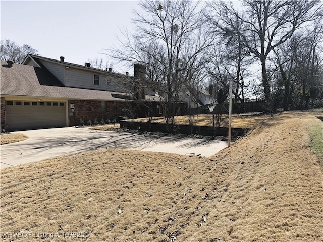 view of yard featuring driveway and an attached garage