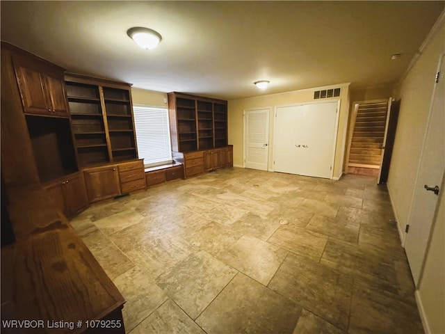 unfurnished living room featuring stairs and visible vents