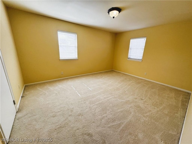 carpeted spare room with baseboards