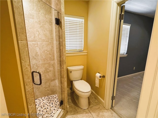 full bath featuring toilet, a stall shower, tile patterned flooring, and baseboards