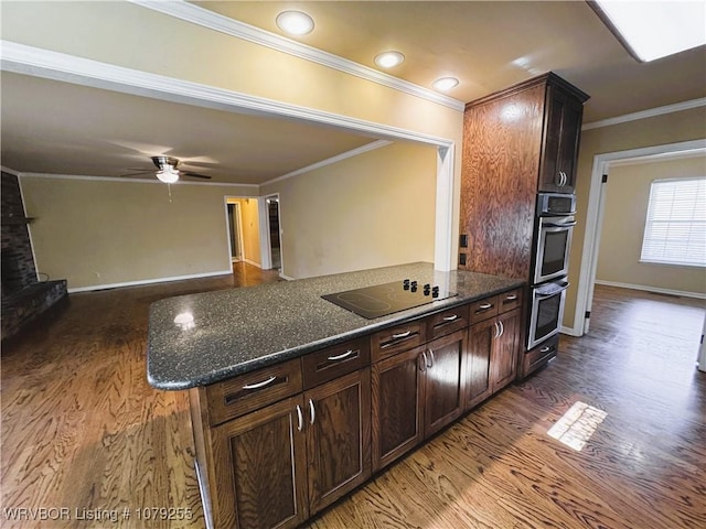 kitchen with double oven, ornamental molding, a peninsula, and black electric cooktop