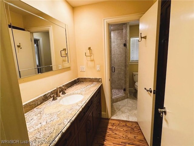 full bathroom with vanity, a shower stall, and toilet