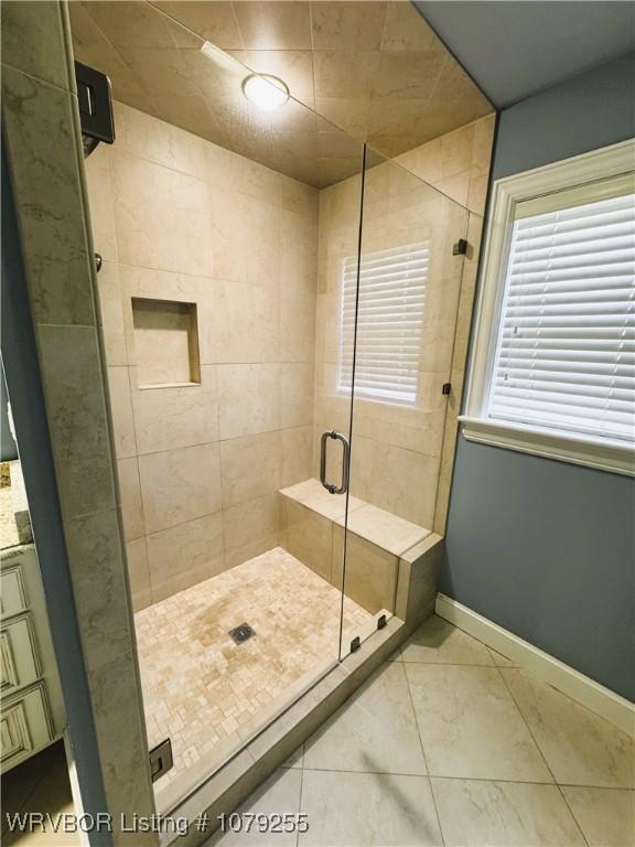 bathroom with a stall shower and baseboards