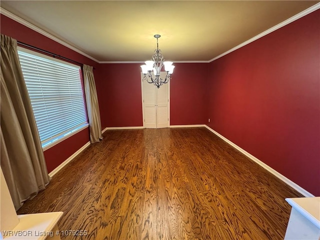 spare room featuring a notable chandelier, baseboards, crown molding, and wood finished floors