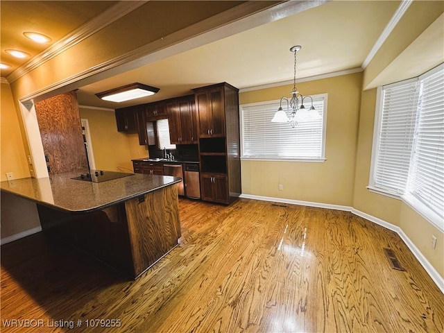 kitchen featuring light wood finished floors, visible vents, ornamental molding, a sink, and dishwasher