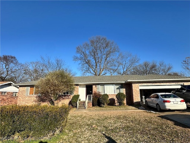 ranch-style home featuring a front yard, brick siding, driveway, and an attached garage