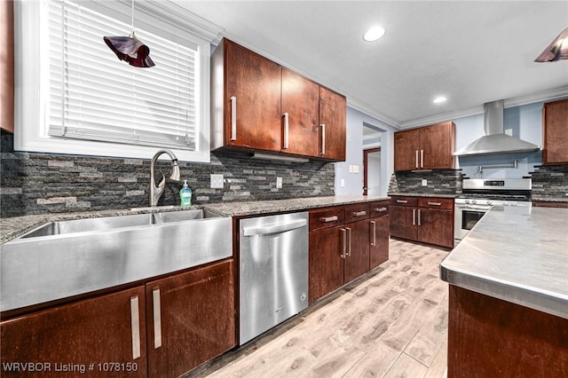 kitchen with wall chimney range hood, crown molding, sink, light wood-type flooring, and appliances with stainless steel finishes