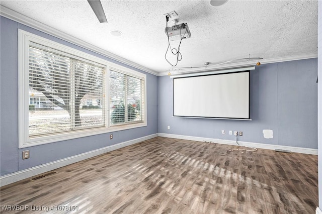 cinema featuring hardwood / wood-style floors, ornamental molding, and a textured ceiling